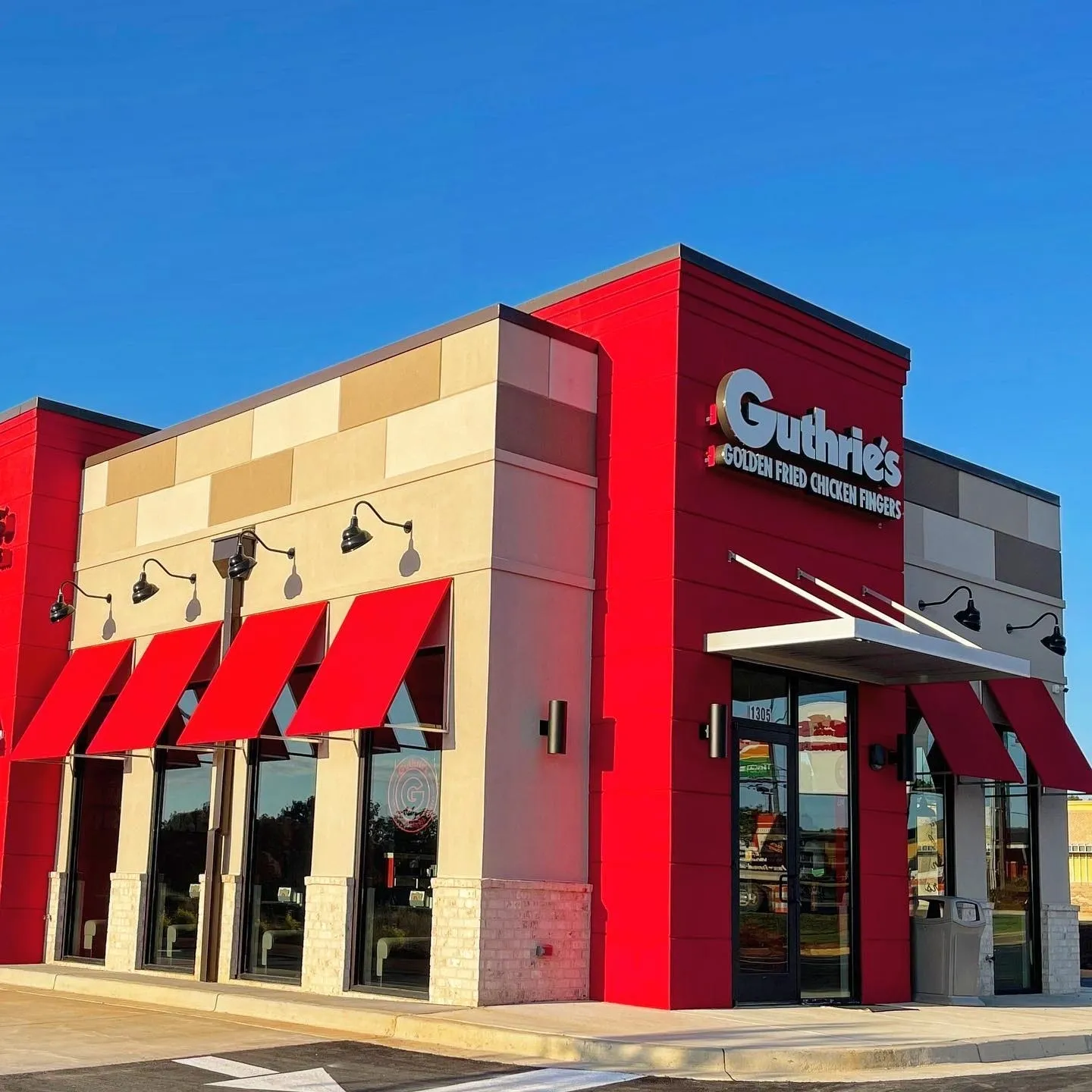 A red and tan building with awnings on the side.